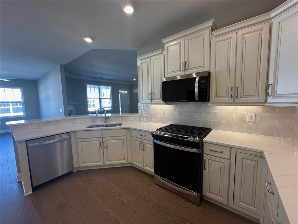 1001 Calypso Way, Unit 1001 Cumming, GA 30040 - Photo 4 of 27 a kitchen with granite countertop a stove a sink and a microwave