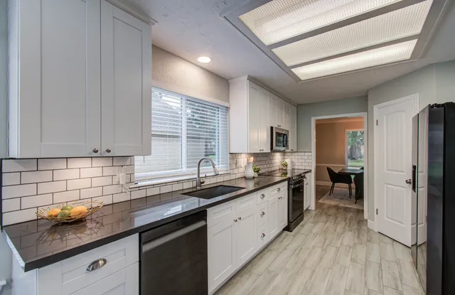 a kitchen with sink a stove and cabinets