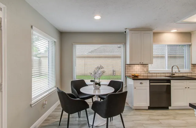 a kitchen with a table chairs sink and microwave