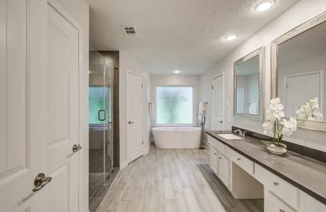 a spacious bathroom with a double vanity sink and a large mirror