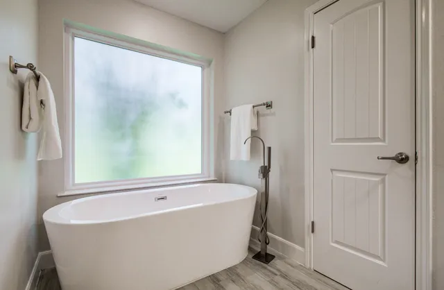 a white bath tub sitting next to a shower