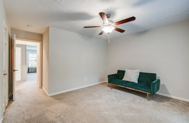 a living room with furniture and a ceiling fan
