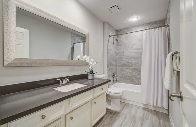 a bathroom with a double vanity sink toilet and shower