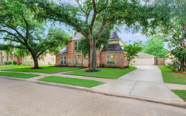 a front view of a house with a yard and an trees