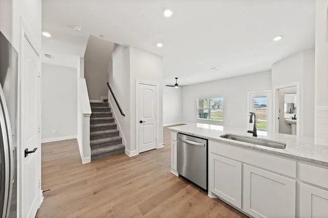 a kitchen with sink cabinets and wooden floor