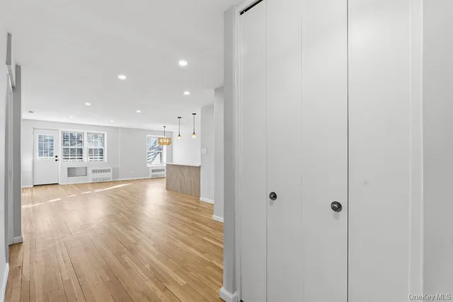 a view of empty room with wooden floor and windows