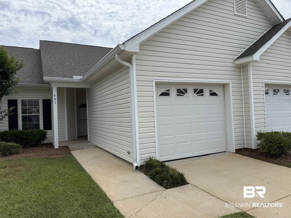 2651 South Juniper Street, Unit 401 Foley, AL 36535 - Photo 2 of 27 View of property exterior featuring a garage, concrete driveway, and roof with shingles