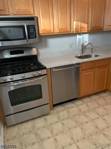 a kitchen with granite countertop a stove top oven microwave and cabinets