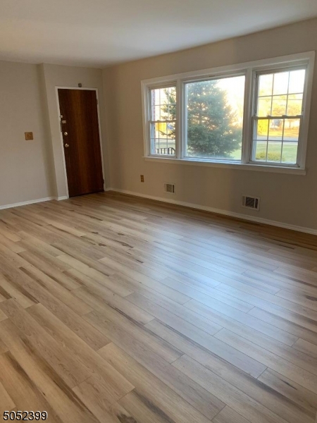 31 Morgan Lane, Unit 2A Bridgewater, NJ 08807 - Photo 6 of 12 an empty room with wooden floor and windows