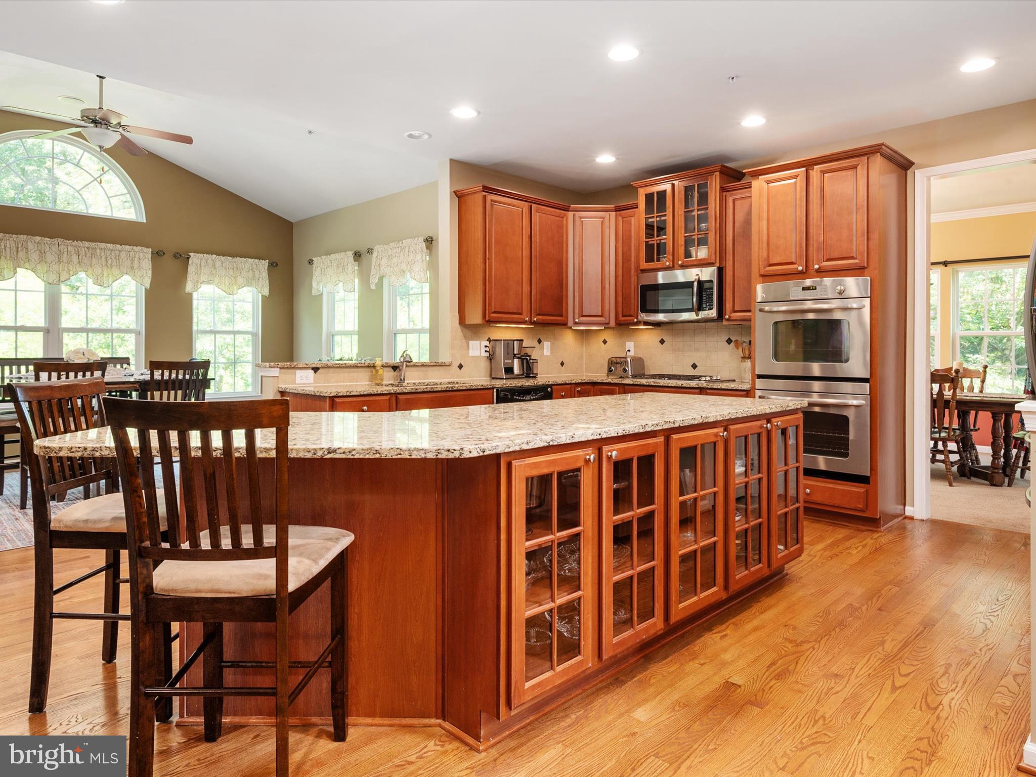 10518 Windlass Run Road Baltimore, MD 21220 - Photo 16 of 71 a kitchen with stainless steel appliances granite countertop a stove a sink a dining table and chairs