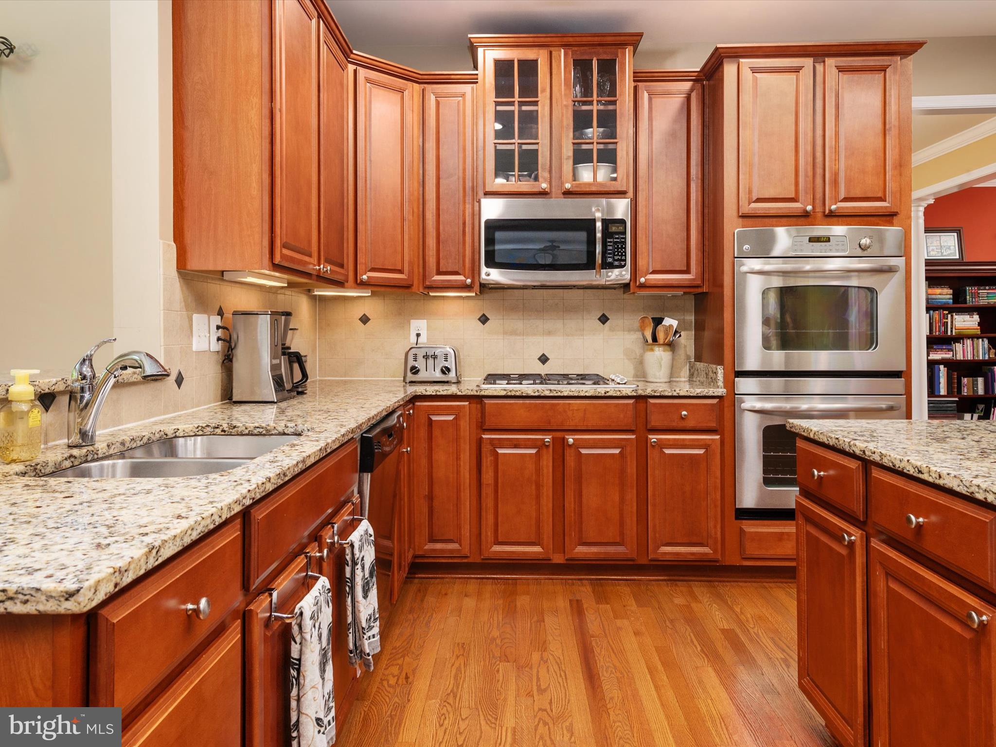 10518 Windlass Run Road Baltimore, MD 21220 - Photo 17 of 71 a kitchen with stainless steel appliances granite countertop a stove a sink dishwasher and a microwave oven with wooden floor