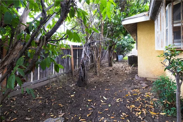a backyard of a house with lots of plants and trees