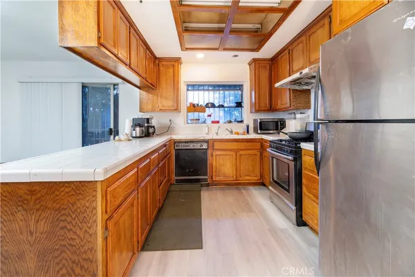 a large kitchen with stainless steel appliances granite countertop a stove a sink dishwasher and a refrigerator