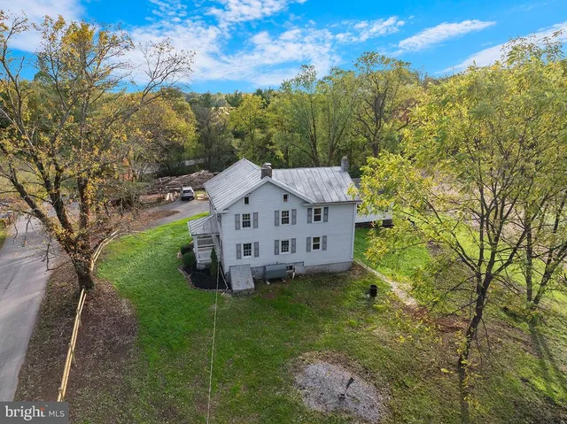 a view of a house with a big yard and large trees