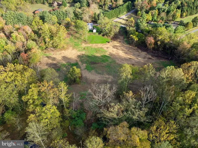 an aerial view of a house with a yard basket ball court and outdoor seating