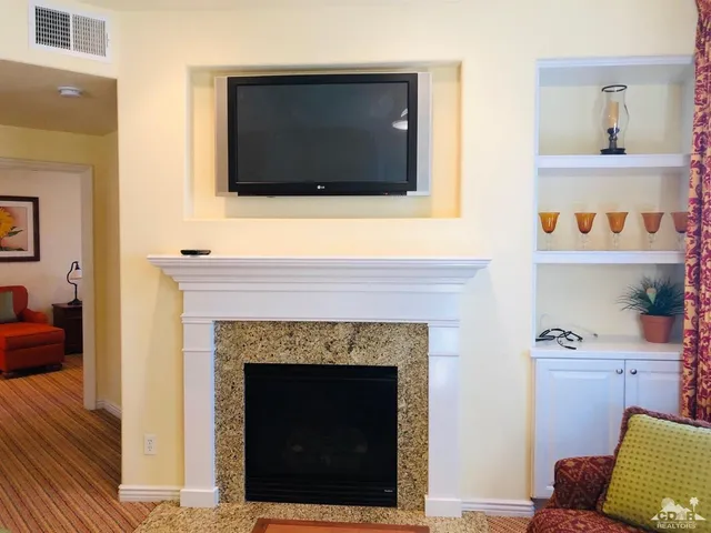 a living room with a fireplace and a flat screen tv