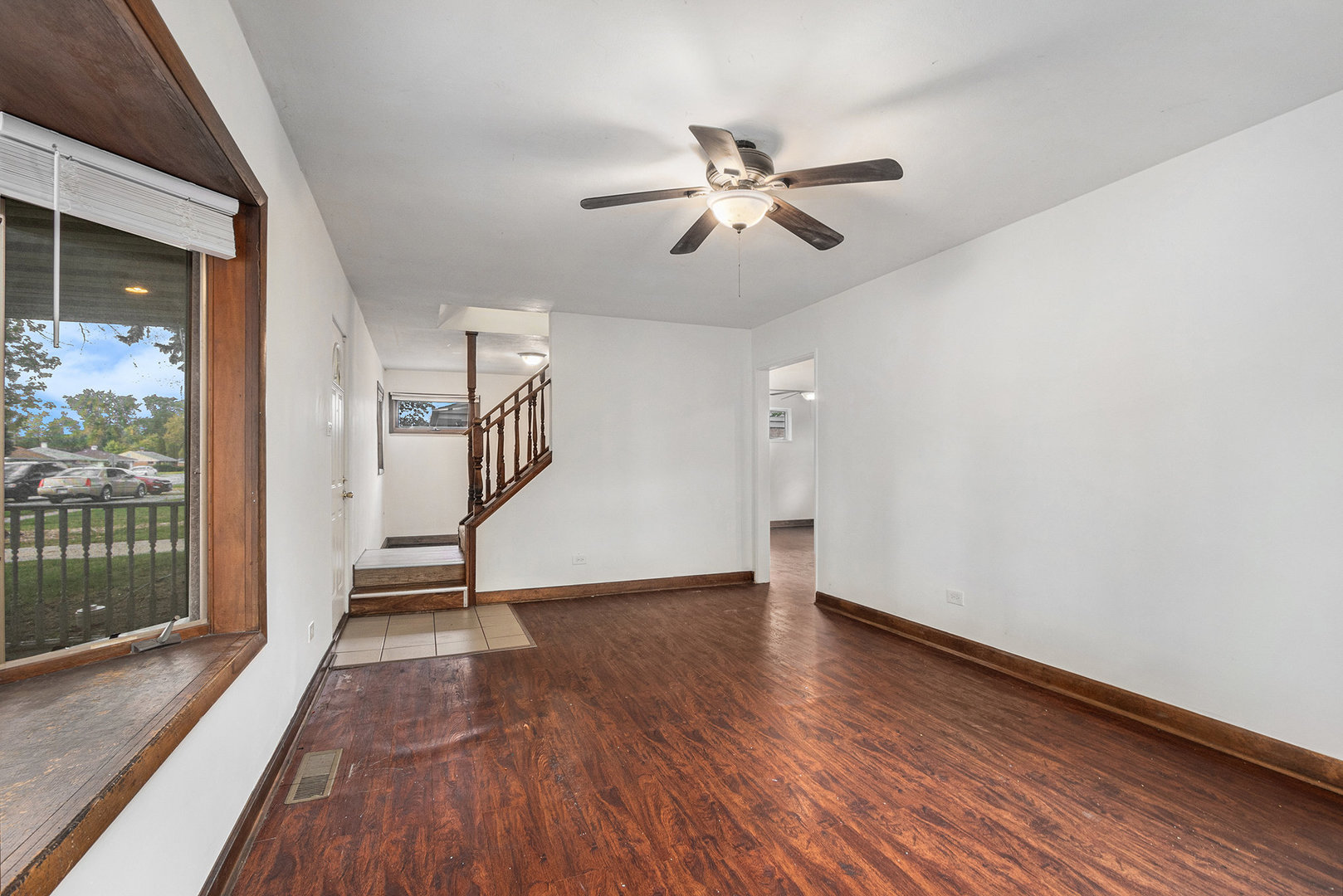 17153 Burnham Avenue Lansing, IL 60438 - Photo 3 of 18 a view of an empty room with wooden floor and a window