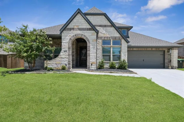 a front view of a house with a yard and garage