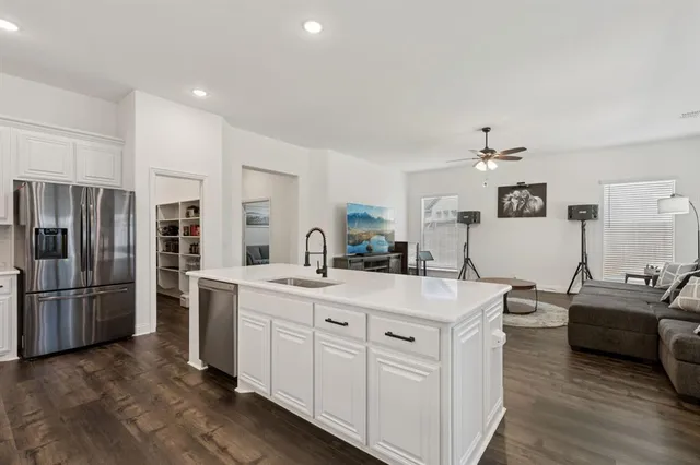 a kitchen with stainless steel appliances granite countertop a sink and refrigerator