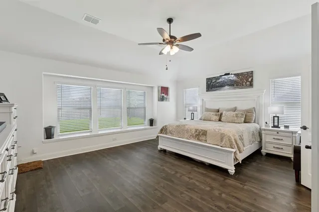 a white bed sitting in a bedroom next to a window