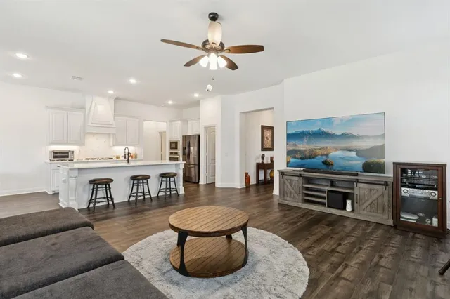 a living room with furniture a flat screen tv and kitchen view