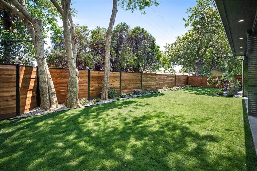 309 Kaye Street Coppell, TX 75019 - Photo 8 of 36 Expansive lawn surrounded by a modern wood-panel fence with dark posts