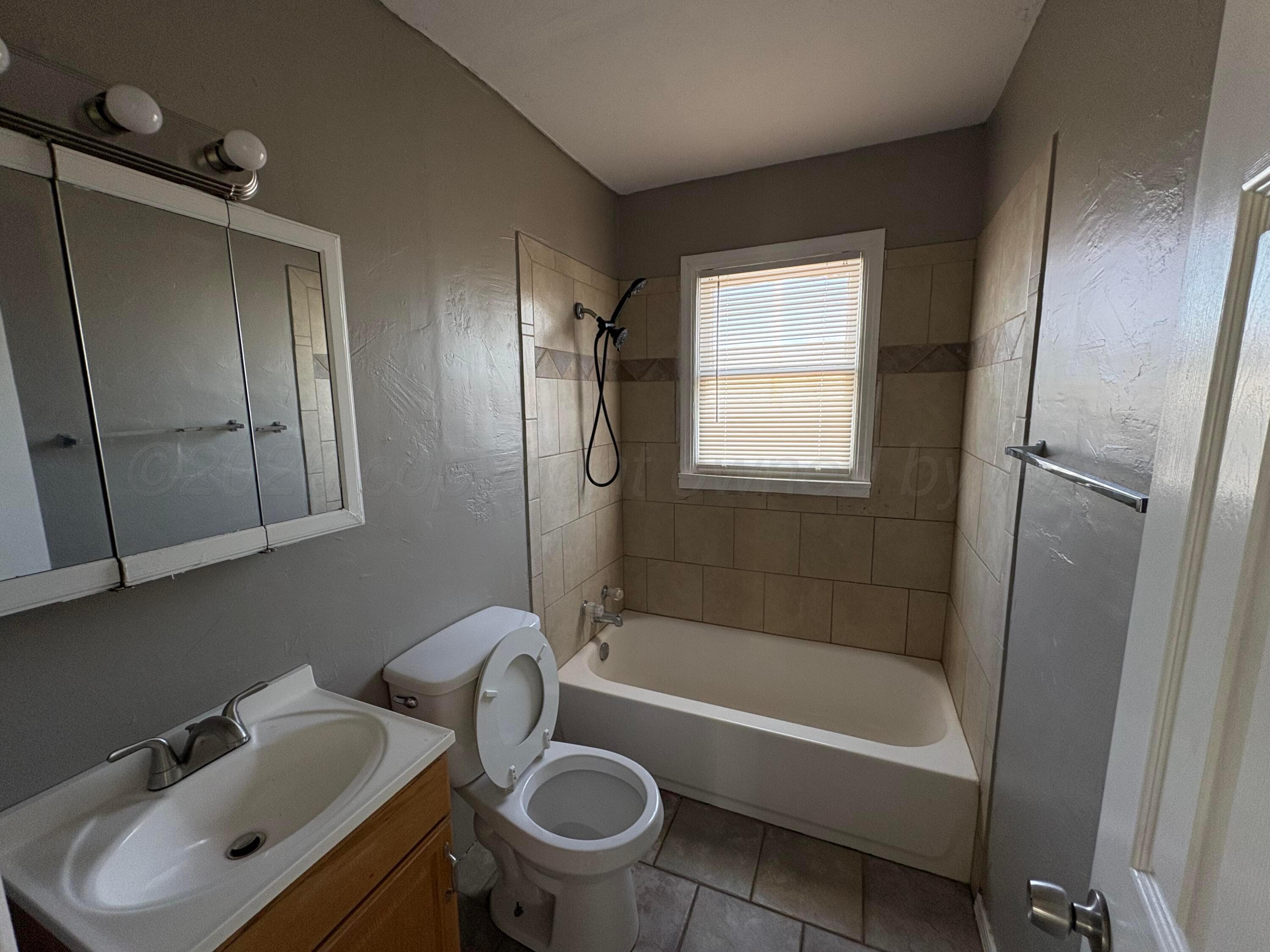 4119 Parker Street Amarillo, TX 79110 - Photo 7 of 8 a bathroom with a sink toilet and shower