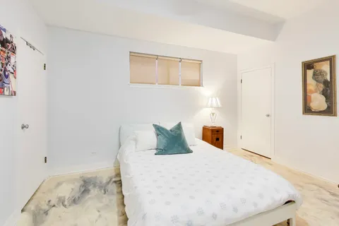 a bedroom with a bed and dresser with mirror