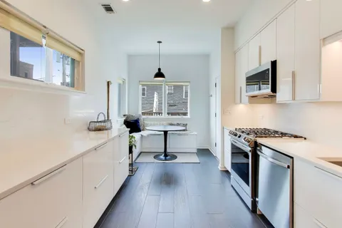 a kitchen with stainless steel appliances a stove a microwave and a hard wood floors