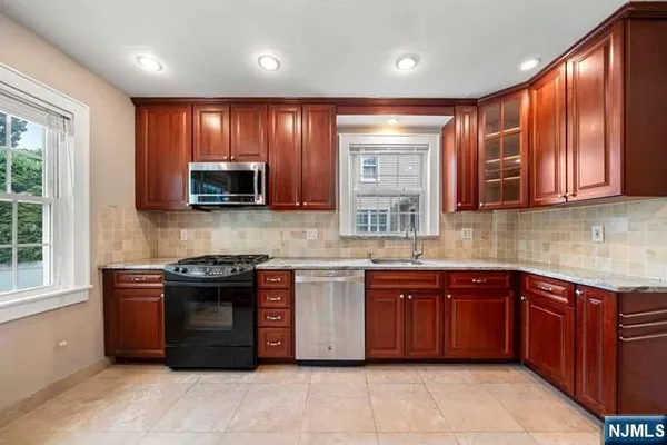 a kitchen with stainless steel appliances granite countertop wooden cabinets a sink and a stove