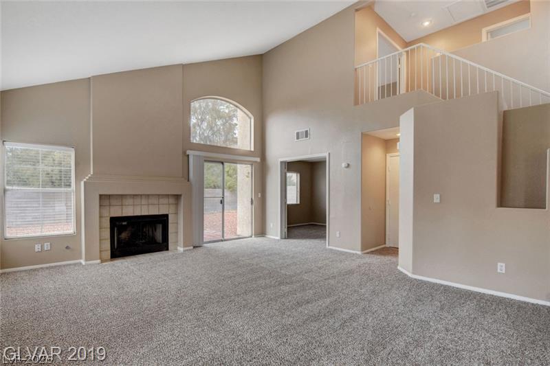 2647 Ridgewater Circle Henderson, NV 89074 - Photo 7 of 26 High ceilings and a classic fireplace anchor this airy, light-filled living area.