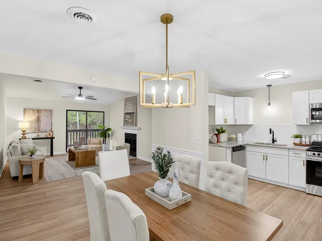 a living room with furniture kitchen view and a wooden floor