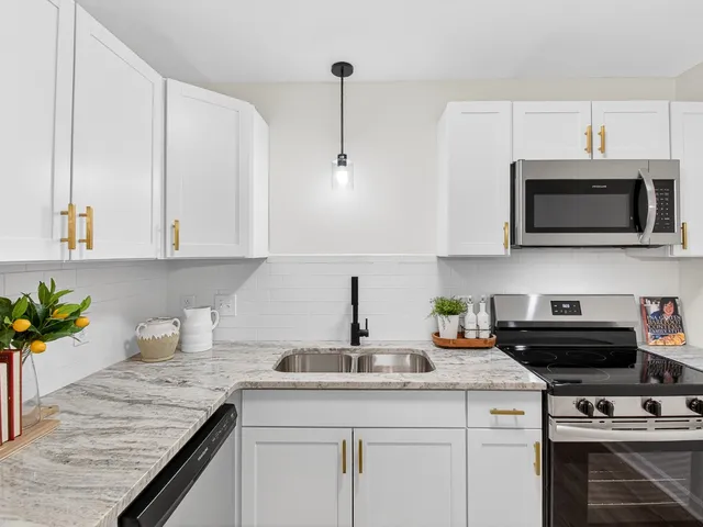 a kitchen with appliances a sink and cabinets
