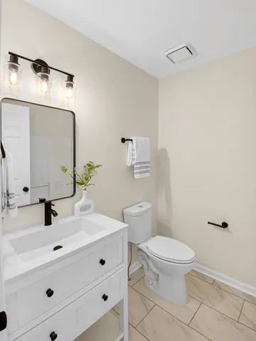 a bathroom with a sink toilet and mirror