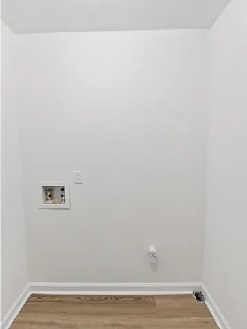 a view of a small space with wooden floor and a potted plant