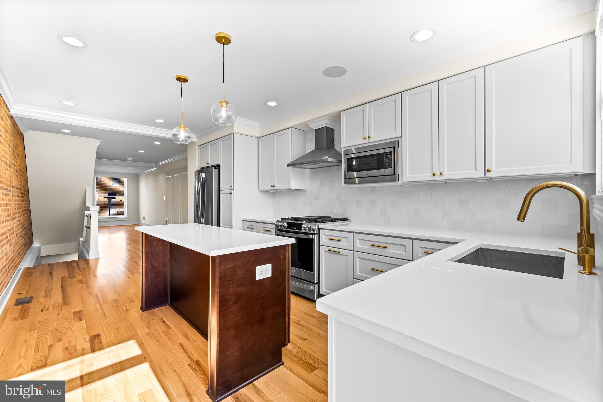 1317 Webster Street Baltimore, MD 21230 - Photo 14 of 32 a kitchen that has a lot of white cabinets and stainless steel appliances