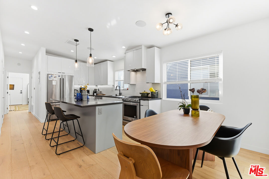 2603 Abbot Kinney Boulevard, Unit 1/2 Venice, CA 90291 - Photo 6 of 16 a kitchen with stainless steel appliances a dining table chairs and refrigerator