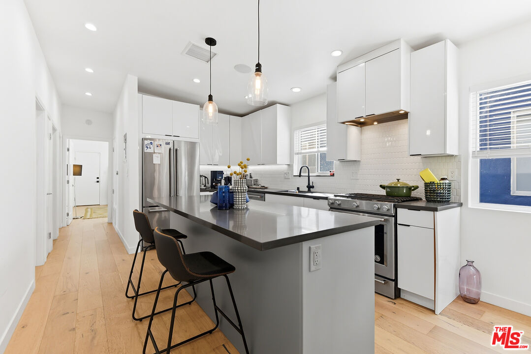 2603 Abbot Kinney Boulevard, Unit 1/2 Venice, CA 90291 - Photo 7 of 16 a kitchen with stainless steel appliances granite countertop a sink a stove a refrigerator and island with wooden floor
