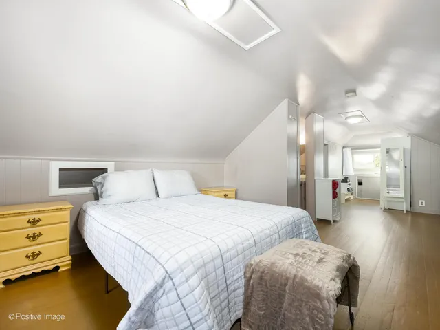 a spacious bedroom with a bed and a chandelier