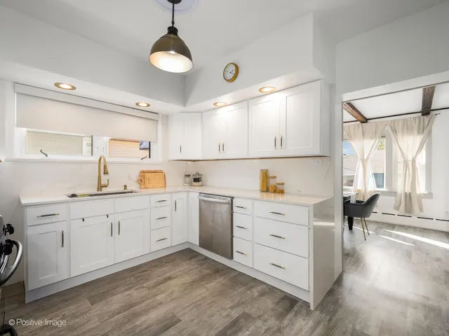 a kitchen with white cabinets and sink