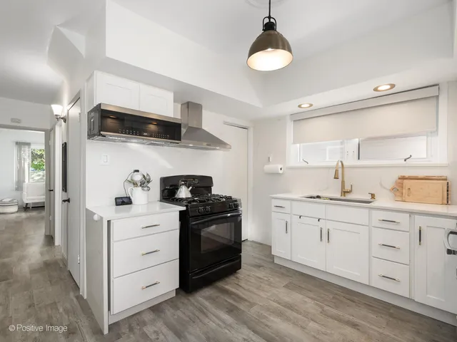 a kitchen with stainless steel appliances granite countertop a stove a sink and a refrigerator