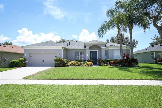 a front view of a house with a garden and trees