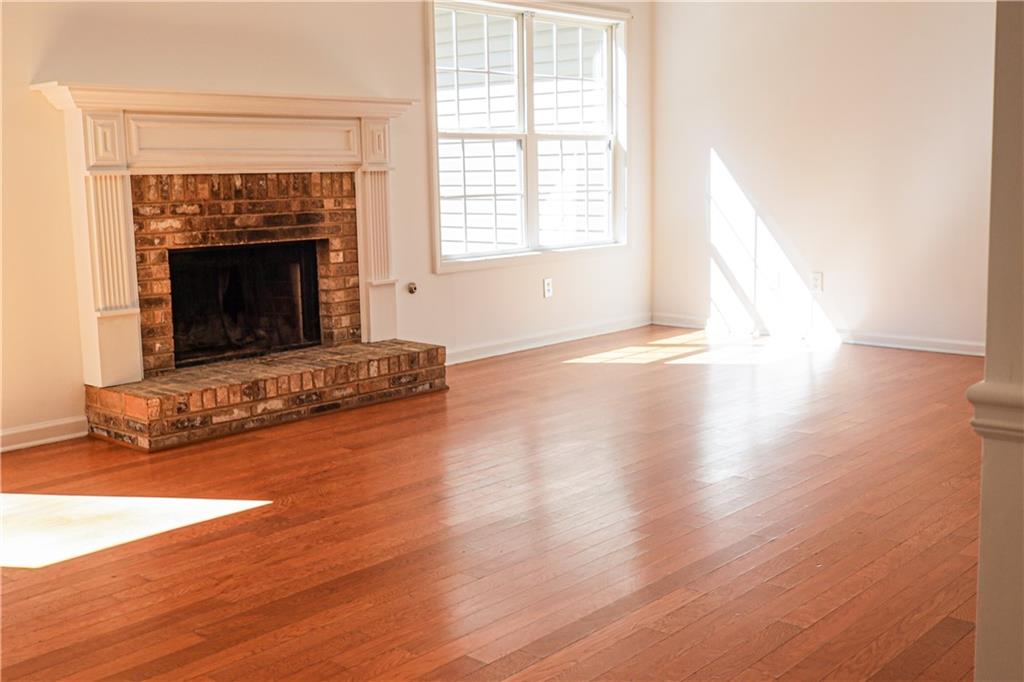 169 Rachel Boulevard Temple, GA 30179 - Photo 4 of 22 an empty room with wooden floor fireplace and windows