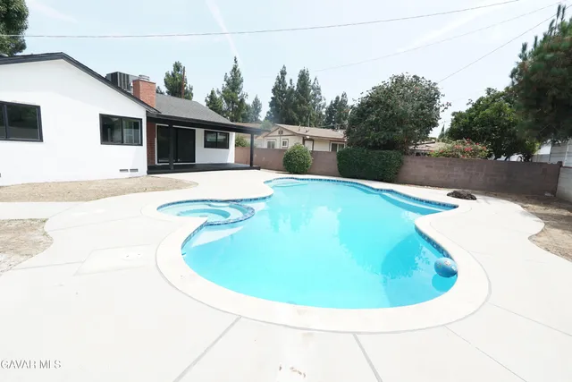 an empty room with wooden floor fireplace and windows