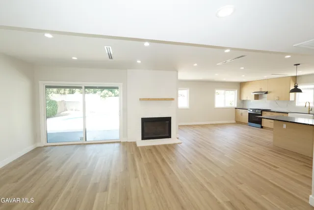 a view of empty room with wooden floor and fireplace