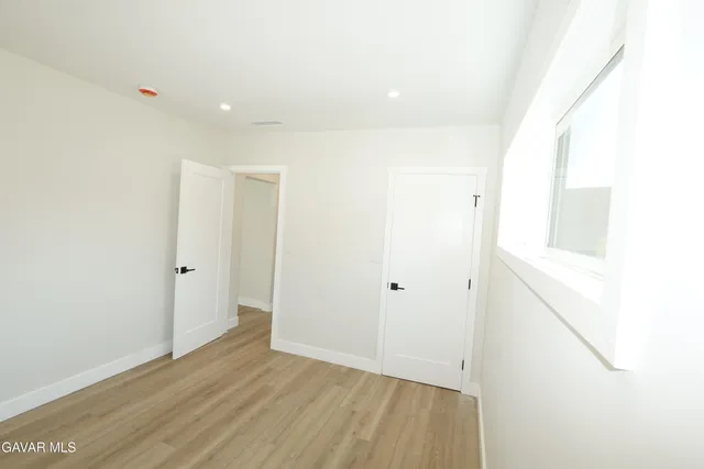 a view of empty room with wooden floor and fireplace
