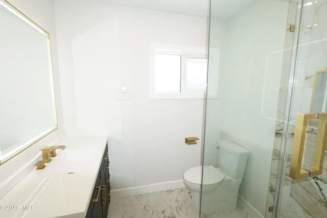 a kitchen with stainless steel appliances kitchen island granite countertop a stove a sink and white cabinets