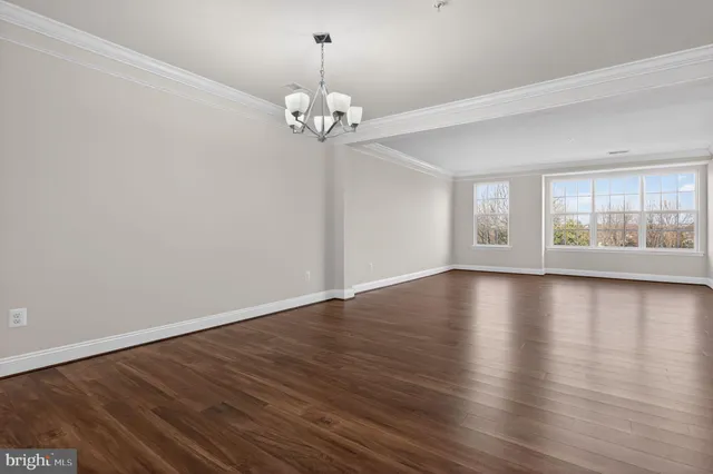 an empty room with wooden floor and window