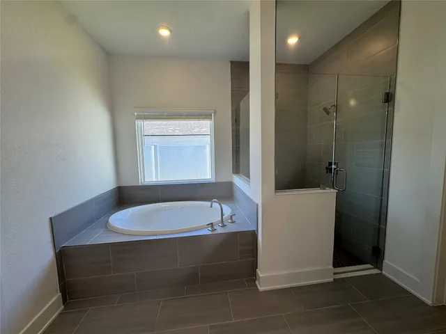 a bathroom with a tub a sink and a window