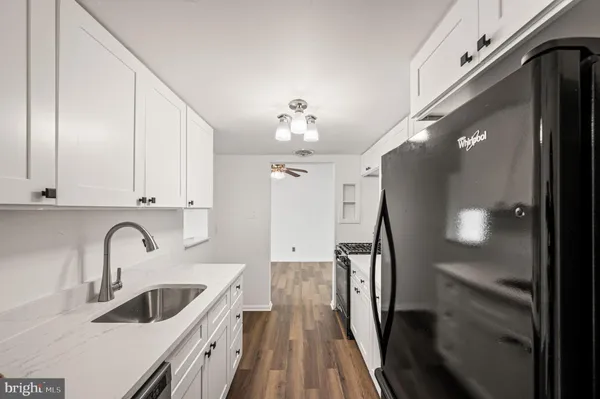 a kitchen with stainless steel appliances granite countertop a sink refrigerator and cabinets